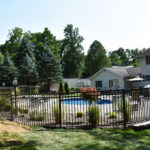 fencing around pool with home in background